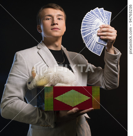 Prestidigitator showing tricks in the dark Prestidigitator showing tricks in the dark 94768286