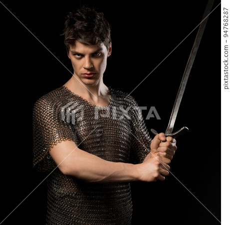 Sexy man in viking hauberg with sword in dark Sexy man in viking hauberg with sword in dark 94768287