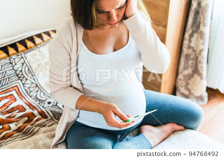 Pregnant thermometer temperature check. Pregnancy woman holding thermometer, check fever flu temperature. Pregnant girl sick. Concept of pregnancy, maternity, expectation for baby birth. Pregnant thermometer temperature check. Pregnancy woman holding thermometer, check fever flu temperature. Pregnant girl sick. Concept of pregnancy, maternity, expectation for baby birth. 94768492