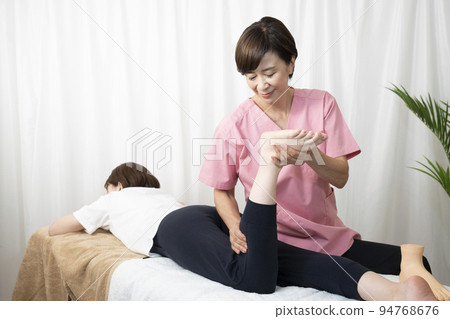 Female chiropractor giving pelvic correction massage Female chiropractor giving pelvic correction massage 94768676