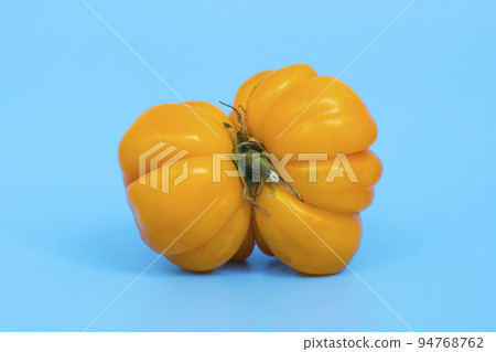 Ugly vegetables concept. Tomatoes of various unusual shapes on a blue minimal background. A metaphor for imperfection, the female body, the art of photography and form. Ugly vegetables concept. Tomatoes of various unusual shapes on a blue minimal background. A metaphor for imperfection, the female body, the art of photography and form. 94768762