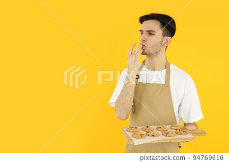 Concept of cooking, young man chef on yellow background 94769616