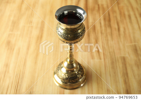 Concept of Eucharist with goblet of wine on wooden background 94769653