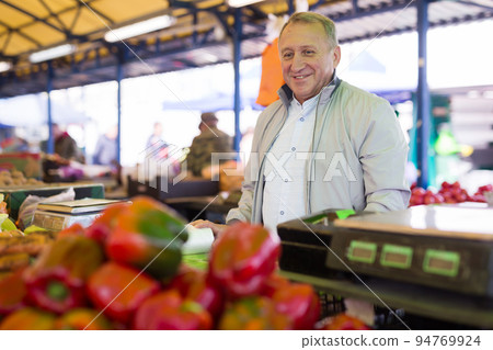 Man purchasing peppers in greengrocery Man purchasing peppers in greengrocery 94769924