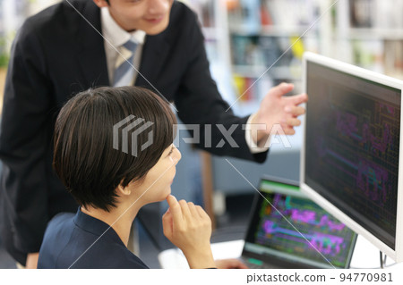 A female designer receiving a lecture on CAD operation from seniors_5 94770981