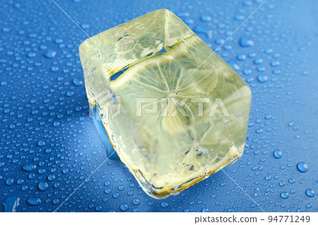 Ice with lemon on wet blue background Ice with lemon on wet blue background 94771249