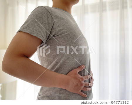 man touching stomach 94771312