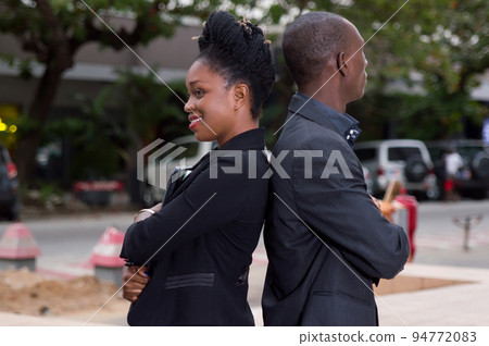 Business people standing back to back outside Business people standing back to back outside 94772083