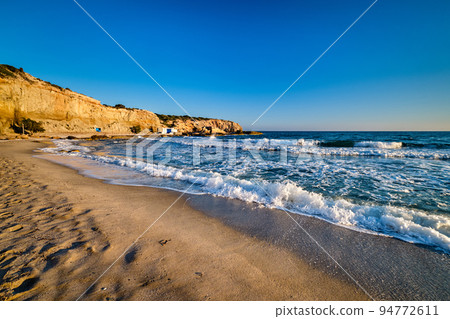 Beautiful sunset view of Fyriplaka beach, Milos island, Greece. Greek vacations, Aegean sea, rocky landscape, azure waters, sandy beach. 94772611