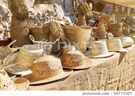 Outdoor market stall selling straw hats Outdoor market stall selling straw hats 94773305
