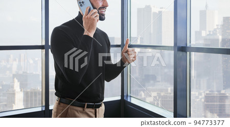 businessman gives a thumbs up. A person uses mobile technologies 94773377