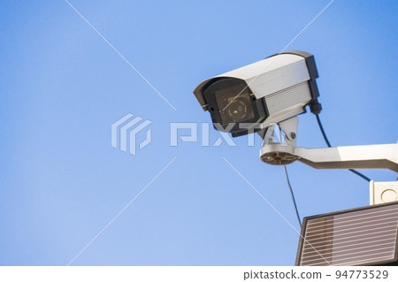 Surveillance camera. surveillance camera. Blue sky background. 94773529