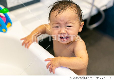 Infant taking a bath 94773907