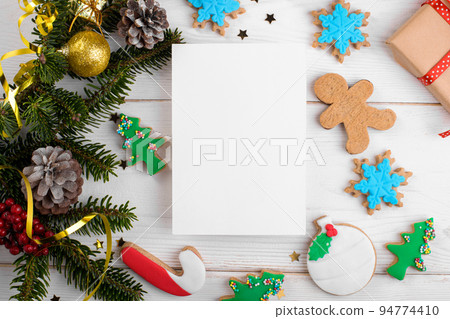 Christmas 5x7 card mockup template with with Christmas gingerbread cookies fir twigs on white wooden background 94774410