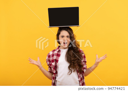 unhappy smart child with laptop on head presenting school online lesson, online education 94774421