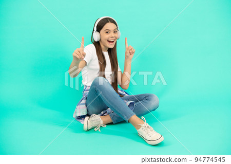 happy child girl listen to music in wireless headphones, device accessory 94774545