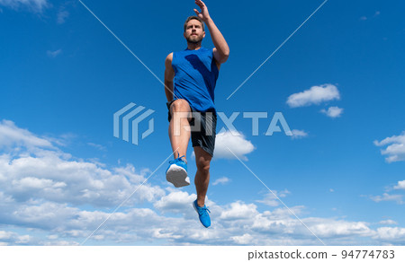 muscular man sprinter running in sportswear outdoor on sky background, marathon 94774783