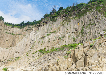 high coastal cliff formed by stone columns, Cape Stolbchaty on Kunashir island high coastal cliff formed by stone columns, Cape Stolbchaty on Kunashir island 94775500