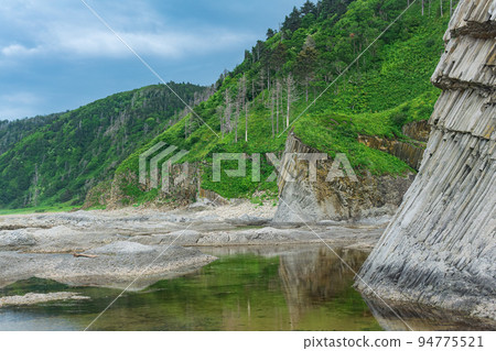 coastal landscape, beautiful wooded rocks on the green coast of Kunashir island coastal landscape, beautiful wooded rocks on the green coast of Kunashir island 94775521