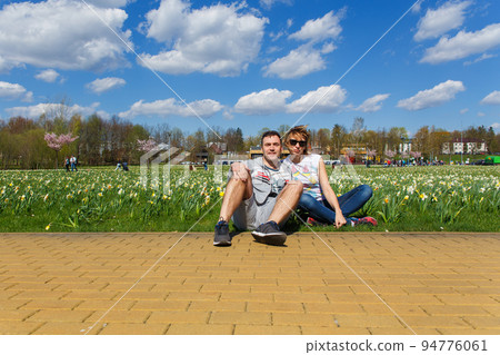 Happy young couple sitting in city park. Happy young couple sitting in city park. 94776061