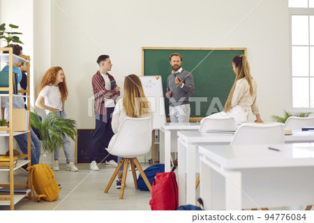 Teacher with whiteboard conducts lesson for students, explaining educational material to them. 94776084