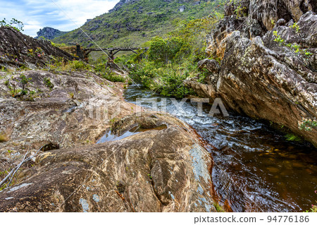 River through the vegetation of the Biribiri reserve with an old wooden bridge built by slaves 94776186
