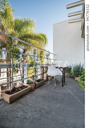 Garden chairs and table in a relaxing, serene, peaceful, lush and private home backyard in summer. 94776332