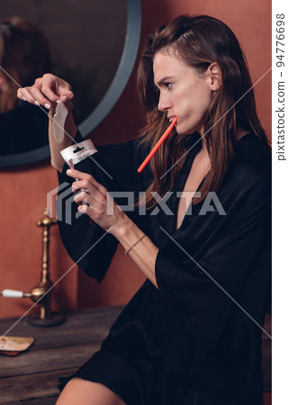 Young woman brushing her teeth, using eye patches 94776698