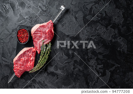 Raw dry aged wagyu picanha barbecue skewer from the cap rump beef with herbs and spices. Black background. Top view. Copy space Raw dry aged wagyu picanha barbecue skewer from the cap rump beef with herbs and spices. Black background. Top view. Copy space 94777208