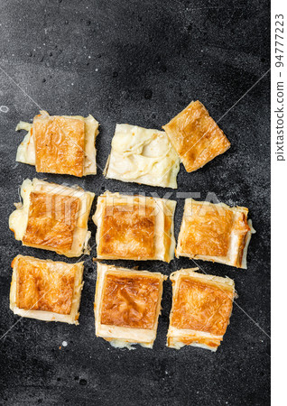 Turkish Su Boregi, Tabla borek or burek with cheese. Black background. Top view Turkish Su Boregi, Tabla borek or burek with cheese. Black background. Top view 94777223