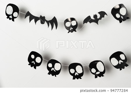Bats and skulls black on white background, place to write greeting. 94777284