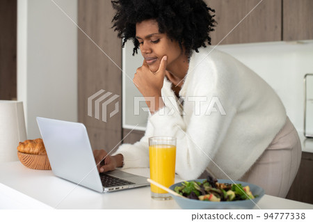 Portrait of young woman working from home typing on laptop 94777338