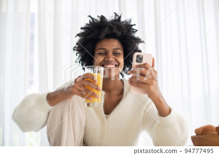 Portrait of young woman working from home with juice Portrait of young woman working from home with juice 94777495