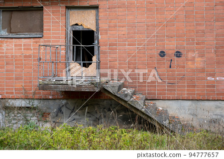 Old damaged wooden door of an abandoned weathered building. 94777657