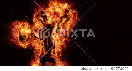 Bodybuilder posing on the fire flames background 94778021