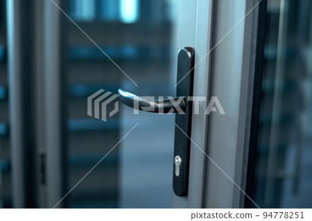 Doorknob with a lock on the glass door. 94778251