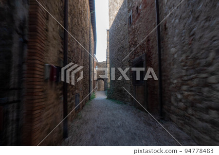 A quiet street of residential buildings in the historic medieval village of Panzano Tuscany 94778483