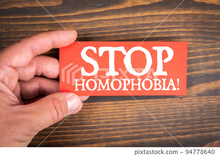 Stop Homophobia. Red piece of paper with a text in a man's hand Stop Homophobia. Red piece of paper with a text in a man's hand 94778640