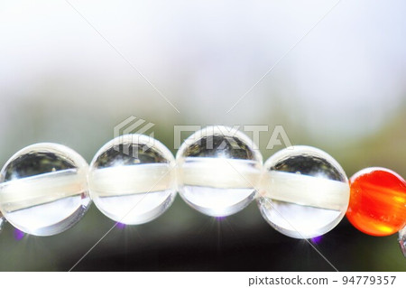 戶外拍攝的透明水晶和紅瑪瑙手鍊的特寫 戶外拍攝的透明水晶和紅瑪瑙手鍊的特寫 94779357