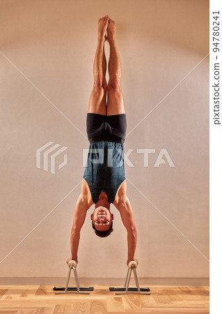 Young man practicing yoga with tree pose, vrksasana asana, stand