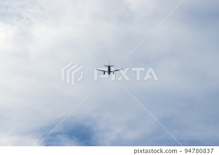the plane is flying against the blue sky 94780837
