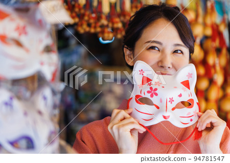 一個穿著和服、戴著狐狸面具的女人在紀念品店 94781547