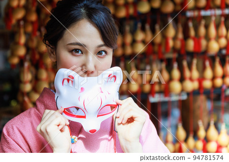一個穿著和服、戴著狐狸面具的女人在紀念品店 94781574