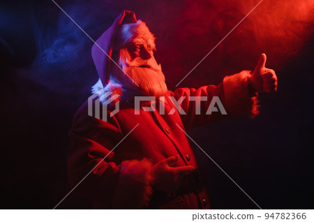 Santa Claus portrait in blue red neon light and smoke. Santa Claus portrait in blue red neon light and smoke. 94782366
