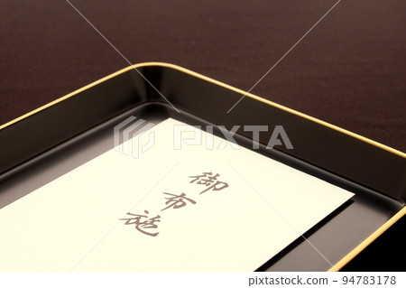 An envelope containing an offering placed on a tray Reward for a monk Image of an offering 1 94783178