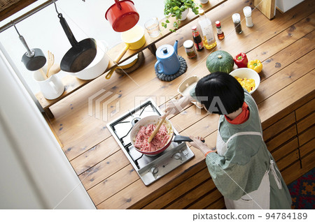 Young woman frying onions and minced meat 94784189