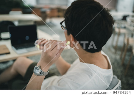 Coworking space user wearing earplugs 94784194