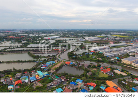 Aerial top view of industry factory in urban city town. Inventory import and export business commercial, Automobile and automotive industry distribution logistic transport with lake and river. Aerial top view of industry factory in urban city town. Inventory import and export business commercial, Automobile and automotive industry distribution logistic transport with lake and river. 94786549