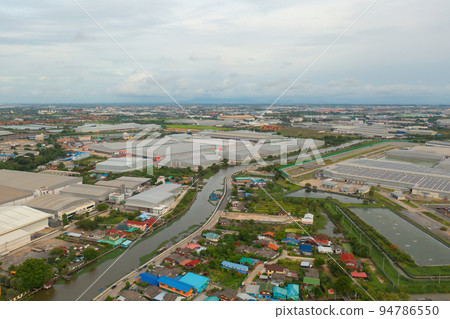 Aerial top view of industry factory in urban city town. Inventory import and export business commercial, Automobile and automotive industry distribution logistic transport with lake and river. 94786550