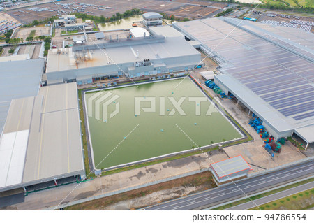 Aerial top view of industry factory in urban city town. Inventory import and export business commercial, Automobile and automotive industry distribution logistic transport with lake and river. 94786554